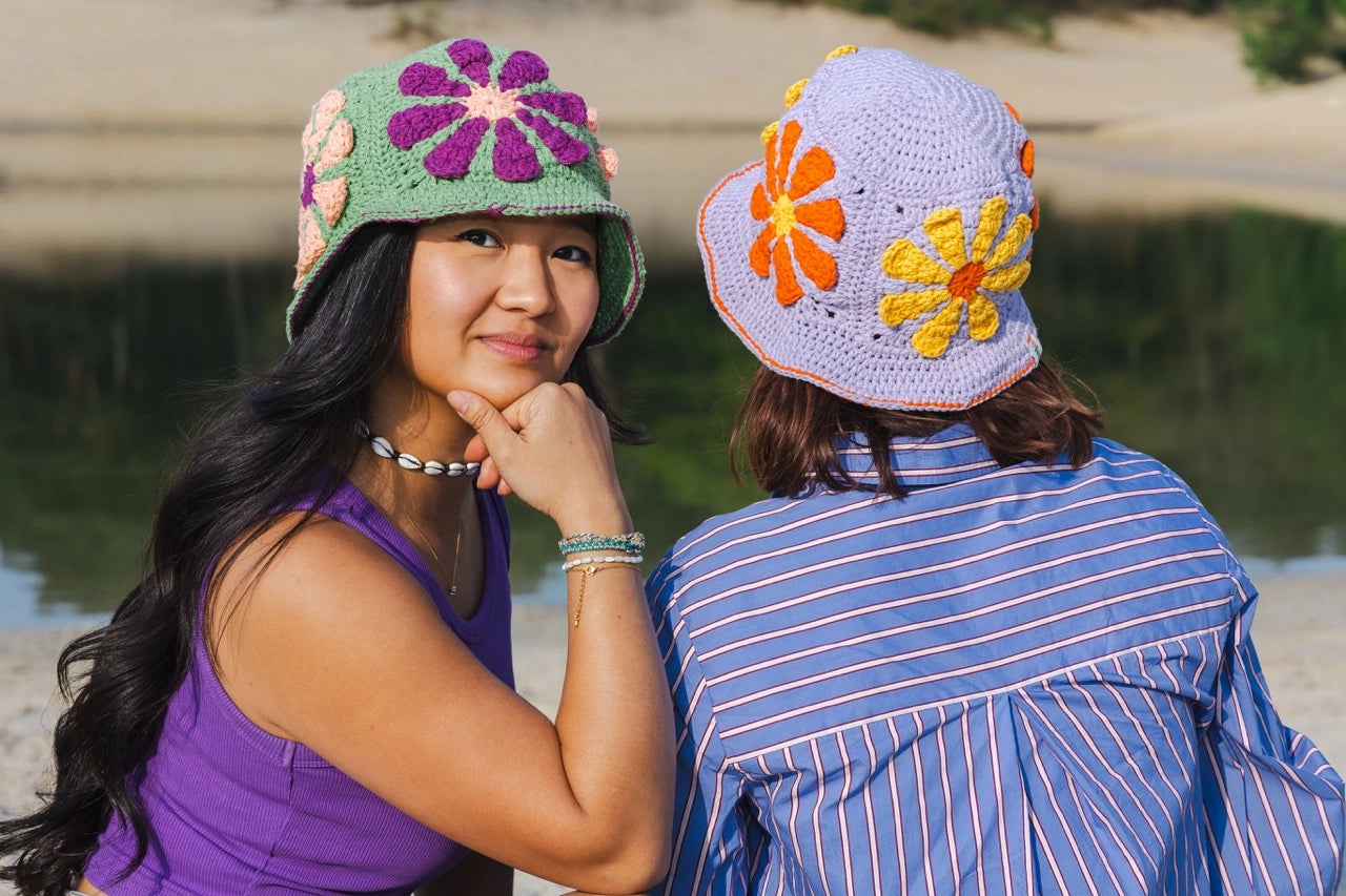 De Festival Bucket Hat van Haakspot in de kleuren groen en lila.