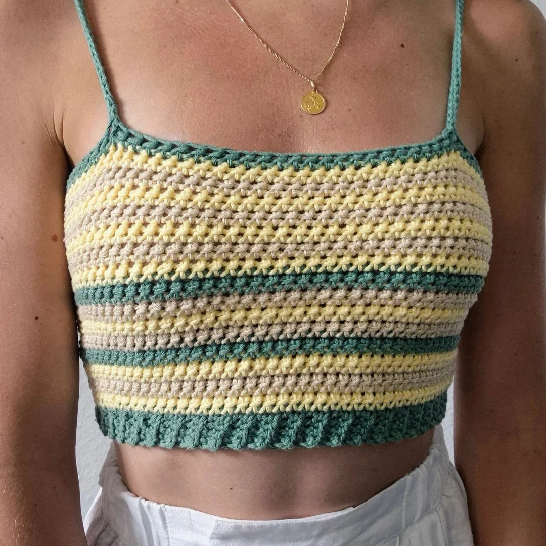Vrouw draagt gehaakte Striped Top met groene, gele en beige strepen en schouderbandjes met strikjes