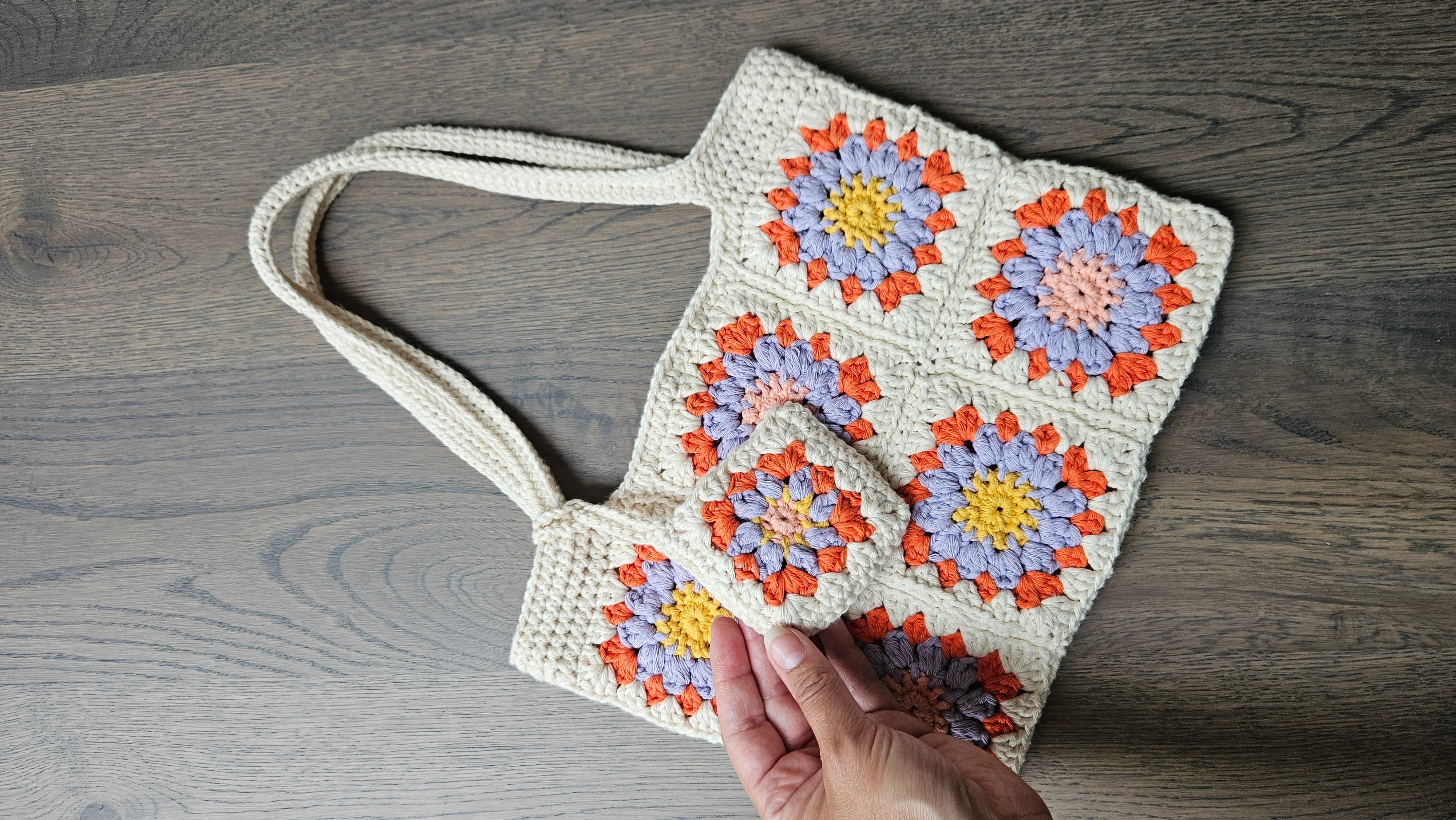 Cream crocheted bag with sunny granny squares in lilac and orange, plus a bag charm.