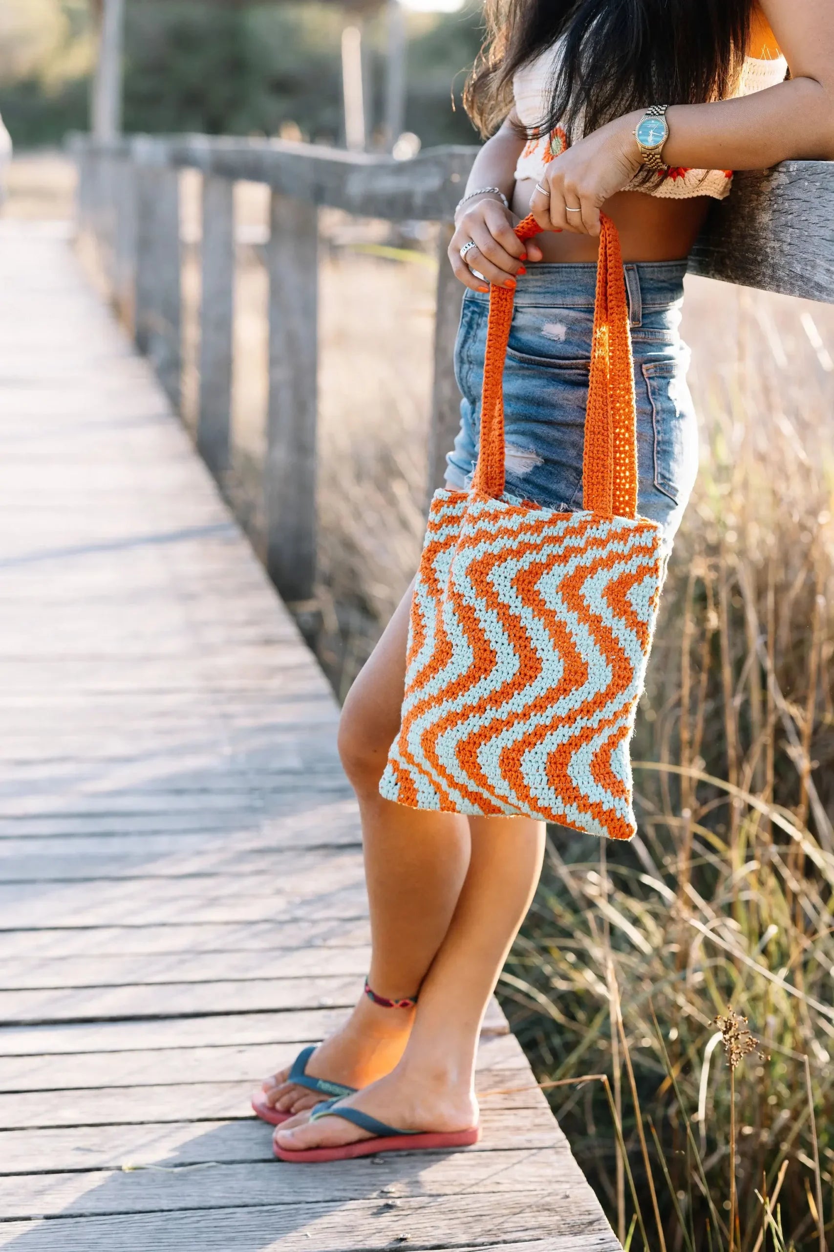 Zigzag bag van Haakspot in een sfeerfoto, vastgehouden door een vrouw.